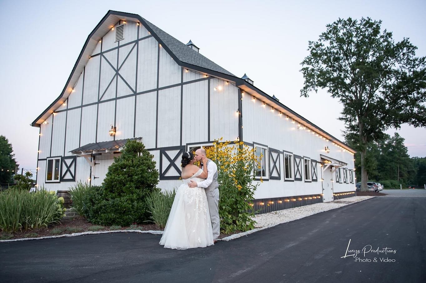 A newly married couple outside the white reception barn at Alturia Farm